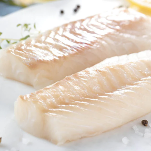 Two pieces of raw hoki fish on a white surface with lemon and herbs. - New Zealand Hoki Boneless and Skinless Fillets (4 Pieces/Pack, 400g)