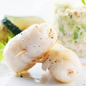 Two skewered hoki fish on a white plate with a blurred background - New Zealand Hoki Boneless and Skinless Fillets (4 Pieces/Pack, 400g)