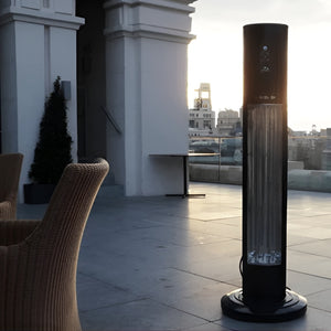Tall cylindrical outdoor heater on a rooftop with chairs and a cityscape in the background - Aussie Meat Infrared Electric Heater Includes Cover & Delivery (Pre-Order 7 Days)