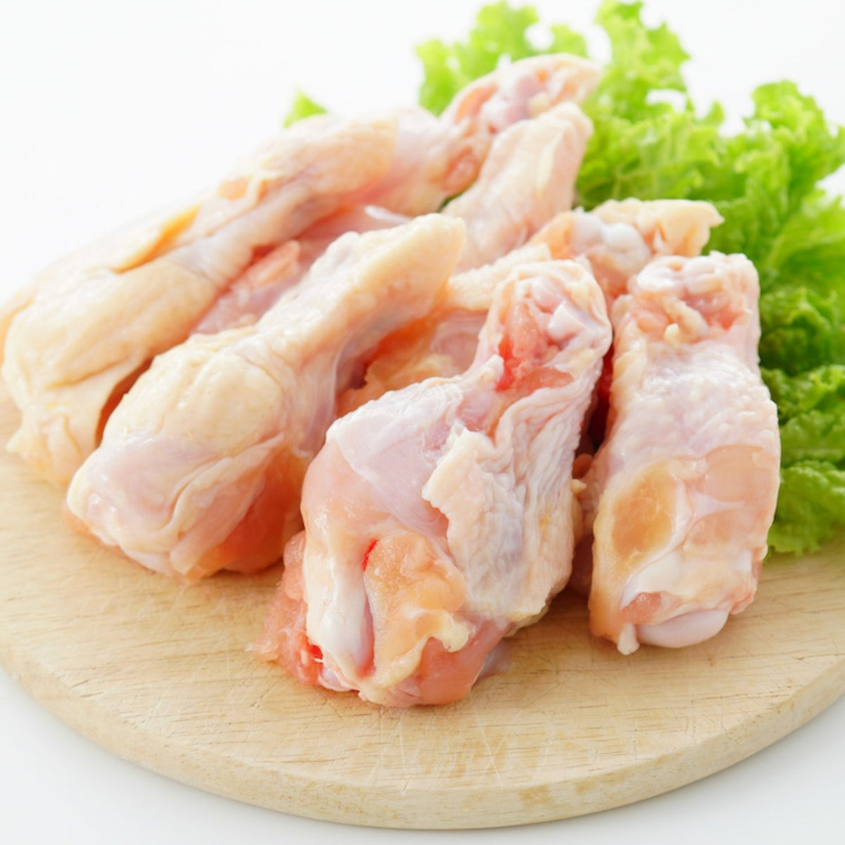 Raw chicken drumettes on a wooden cutting board with green lettuce leaves. - Australian Hormone Free Chicken Drumettes (400g)