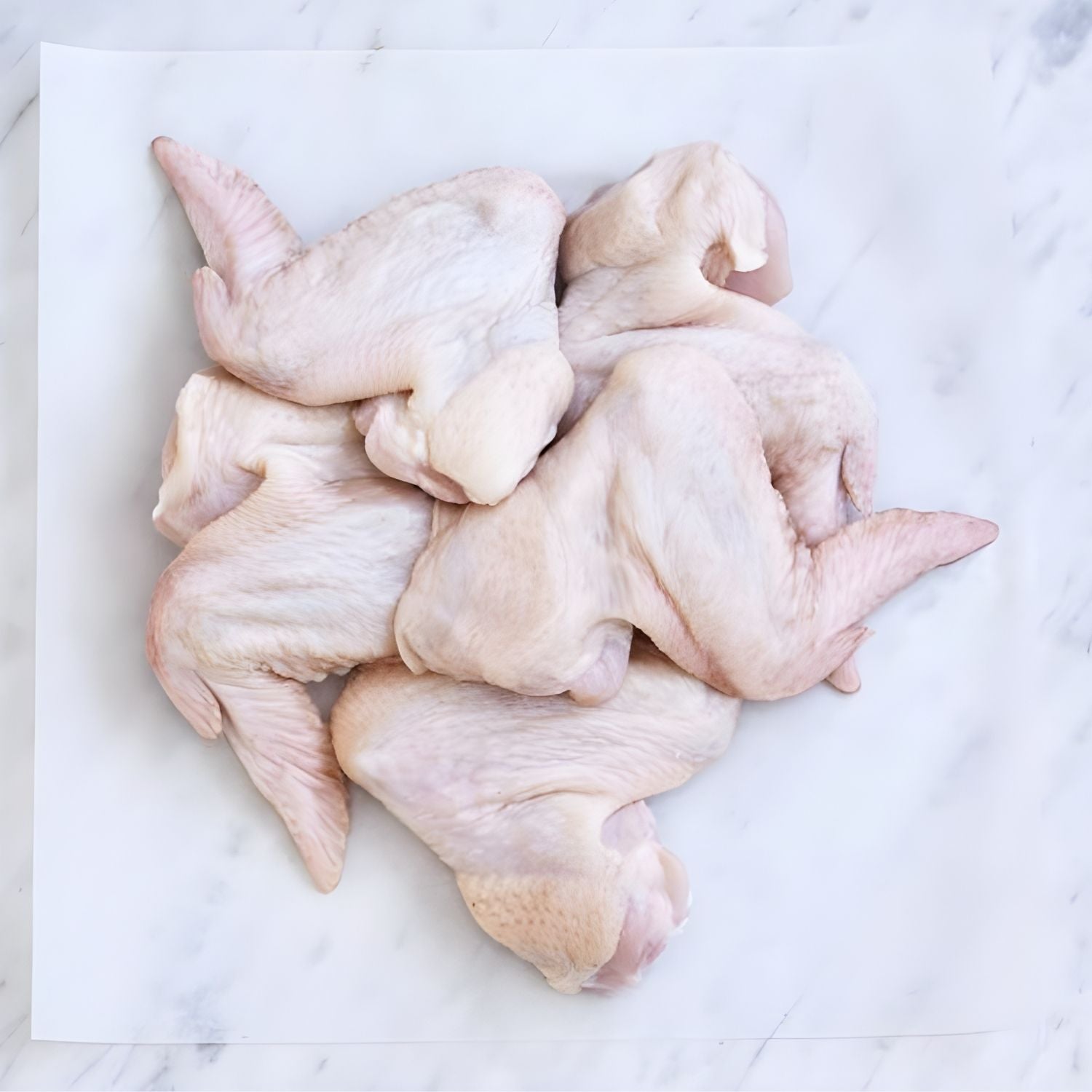 Raw chicken wings on a white marble surface - Australian Hormone Free Chicken Whole Wings (400g)