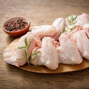 Raw chicken wings on a wooden plate with rosemary and a bowl of spices on a wooden surface. - Australian Hormone Free Chicken Whole Wings (400g)