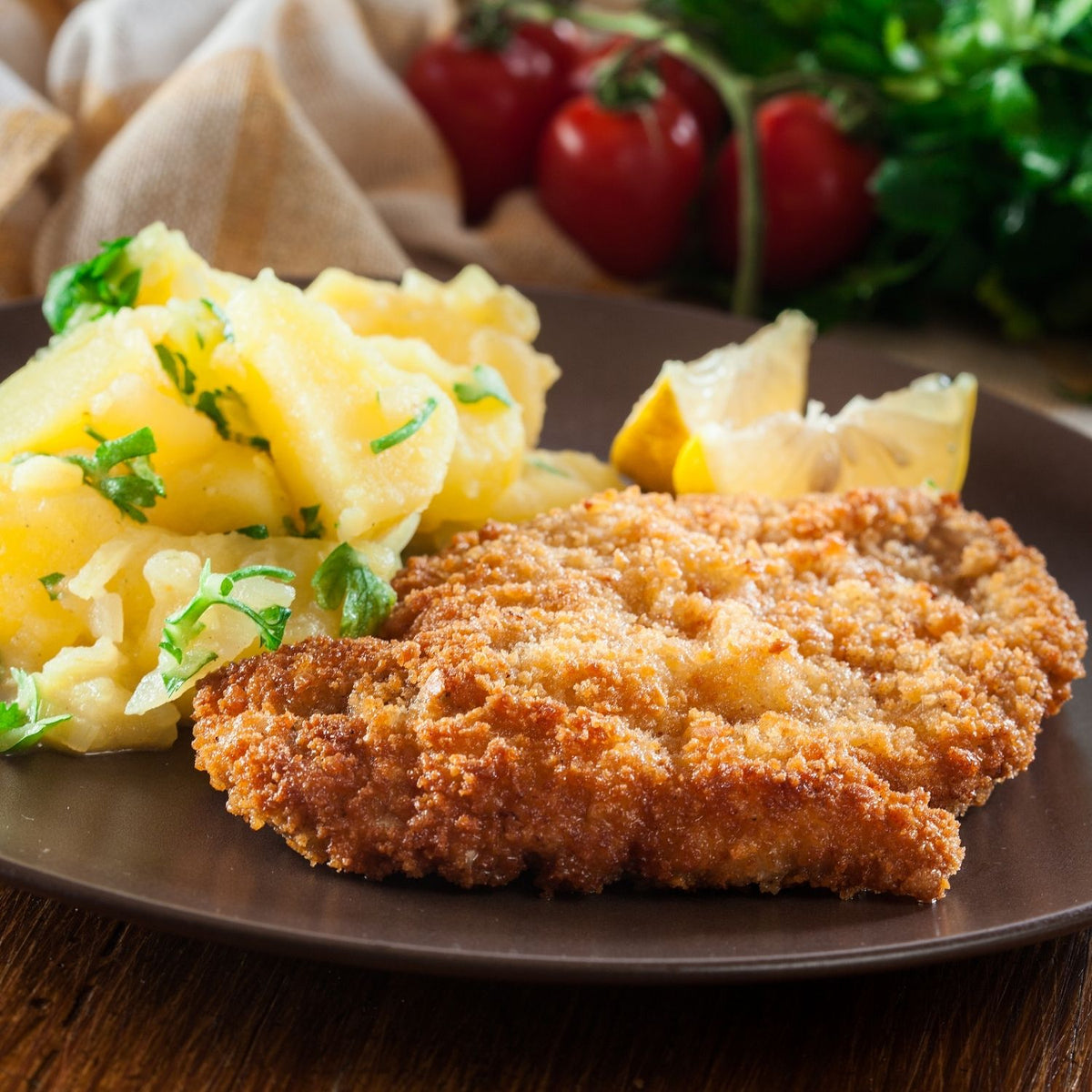 Fried chicken breast schnitzel with mashed potatoes on a plate, surrounded by vegetables. - Australian Hormone Free Cooked Chicken Breast Schnitzel (Skinless & Boneless, 1kg pack, approx 160g per piece)