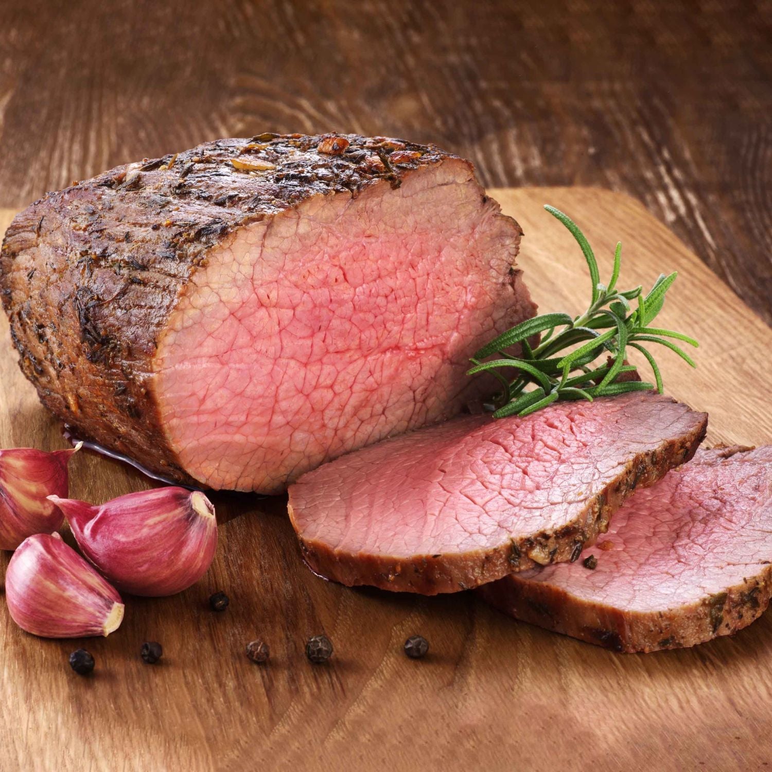 Sliced roasted beef scotch fillet with rosemary and garlic on a wooden cutting board - 澳洲優質黑安格斯肉眼(肋眼,MS 2+,2公斤)