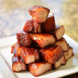 Stack of glazed pork belly on a white plate with a blurred natural background - EU Hormone Free Pork Belly Rind-On (1kg)