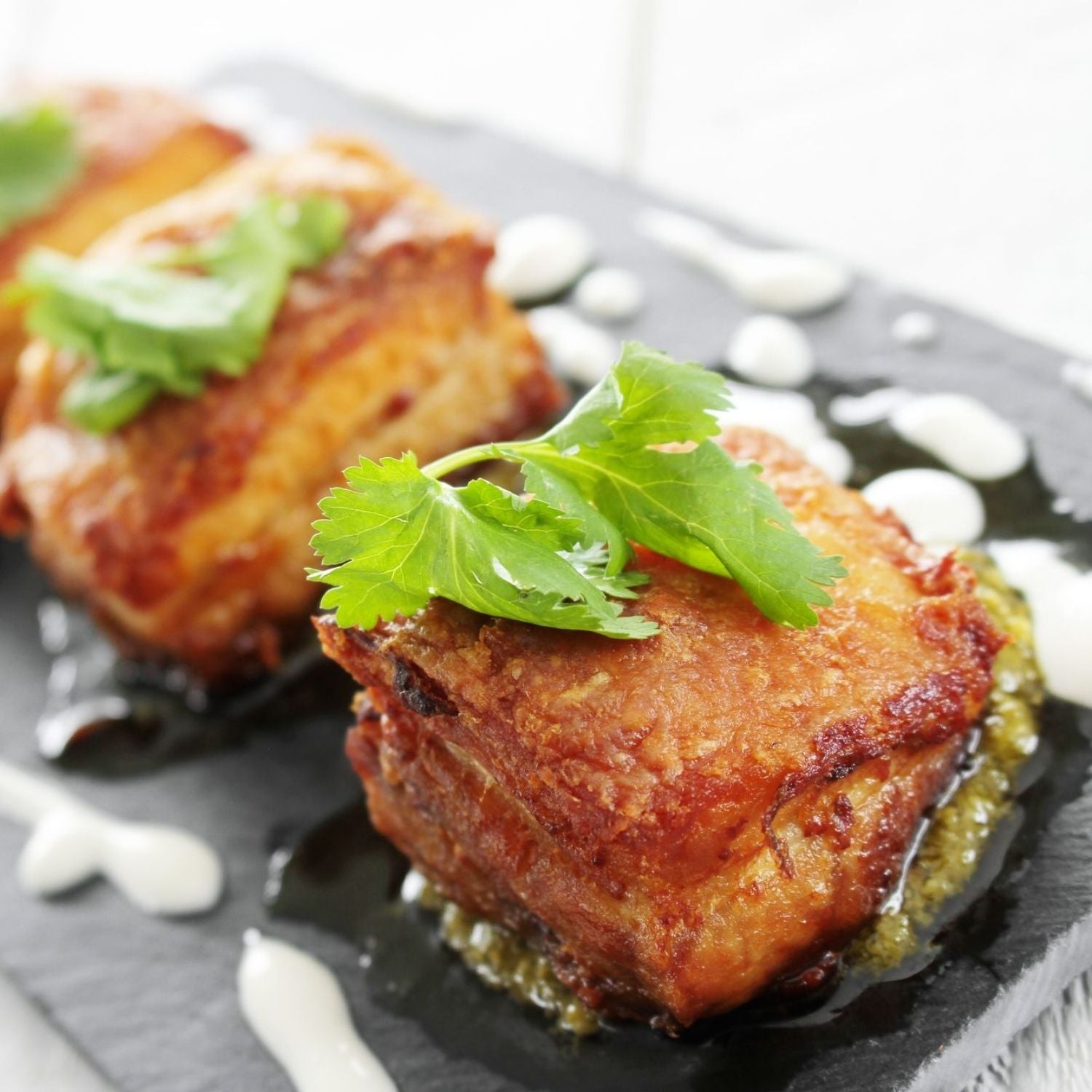 Fried pork belly with green garnish on a black slate plate - EU Hormone Free Pork Belly Rind-On (1kg)