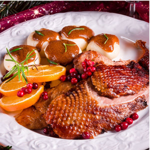 Roast duck leg with potatoes, oranges, and cranberries on a decorative plate. - 無激素法國連皮鴨髀