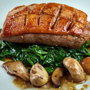 Roasted duck breast with spinach and mushrooms on a plate - French Hormone Free Moulard Duck Breast Skin-On Boneless Fillet