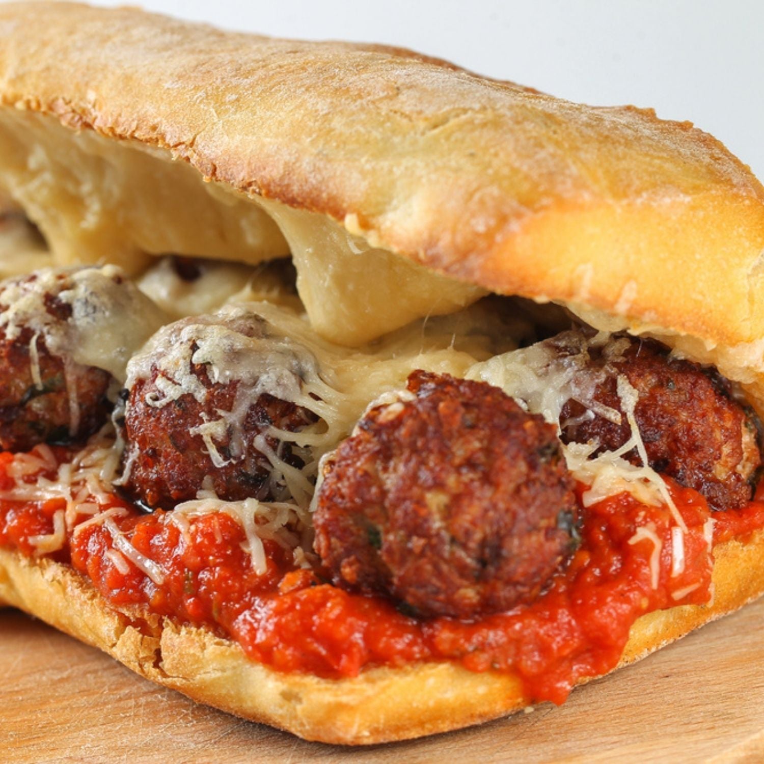 Meatball sub with cheese and tomato sauce on a wooden cutting board - 紐西蘭優質草飼瘦免治牛肉（〜85％VL，500克）