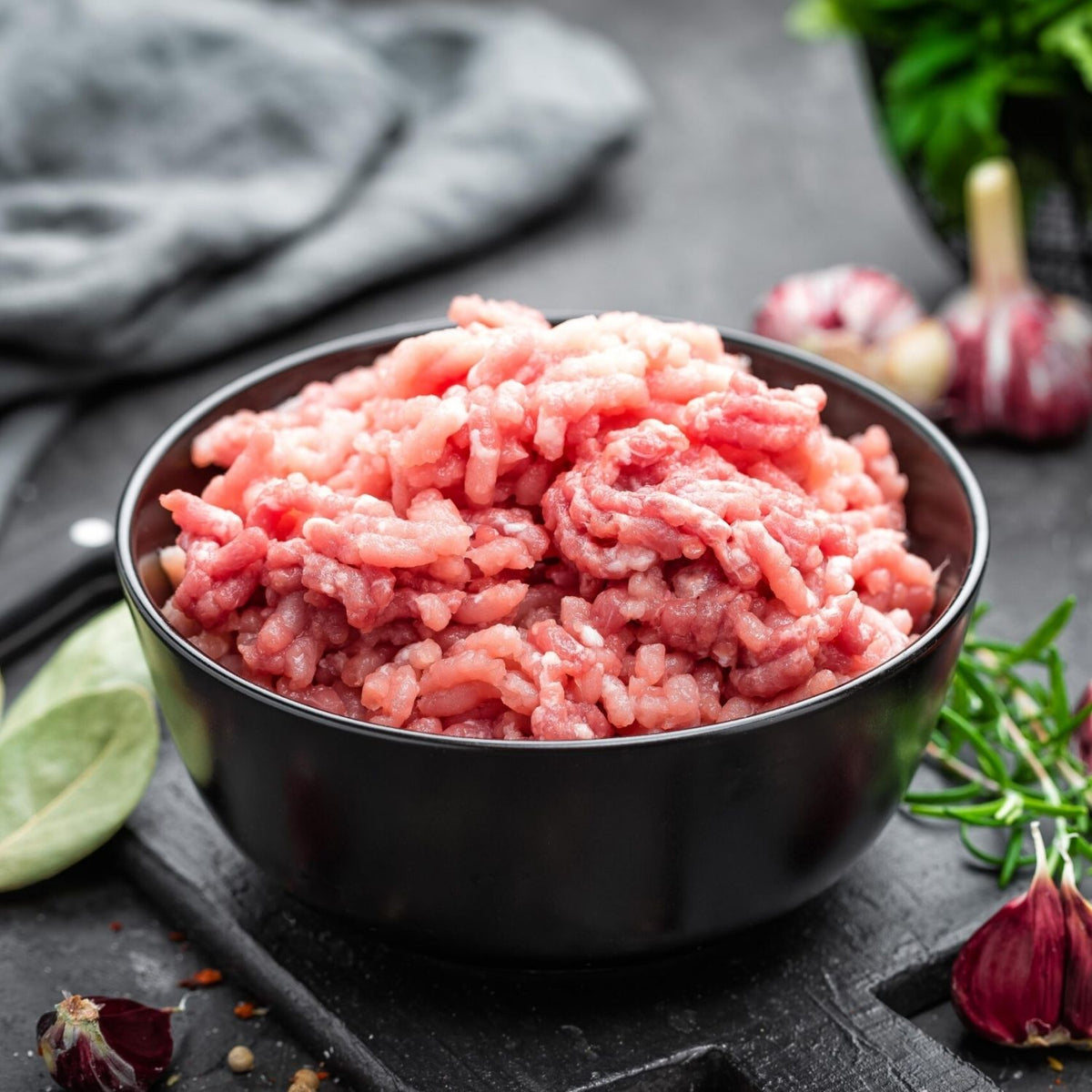 Black bowl filled with minced pork on a dark surface with herbs and spices. - UK Premium Duroc Pork Mince & Hormone Free (300g)