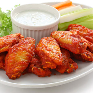 Platter of buffalo wings with a side of ranch dressing, carrots, and celery on a white plate. - 批發價澳洲無激素雞中翼(400克)|買二十送六