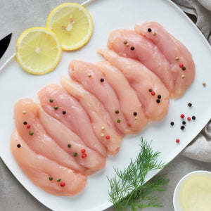 Raw chicken tenderloins on a plate with lemon slices and herbs - Wholesale Australian Hormone Free Chicken Tenderloins (400g) | Buy 20 Get 6 Free