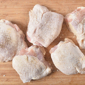Raw chicken thighs on a wooden cutting board with black pepper seasoning - 澳洲無激素連皮雞扒(400克)|買二十送六