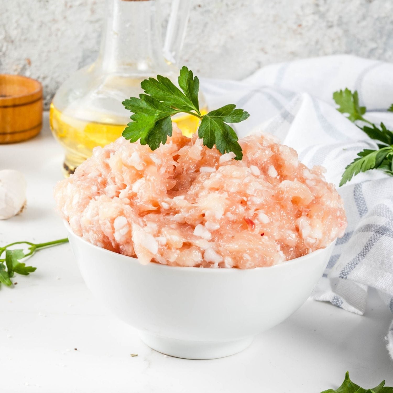 Bowl of ground chicken thigh with parsley on a white surface - 澳洲無激素免治雞髀肉(400克)|買二十送六